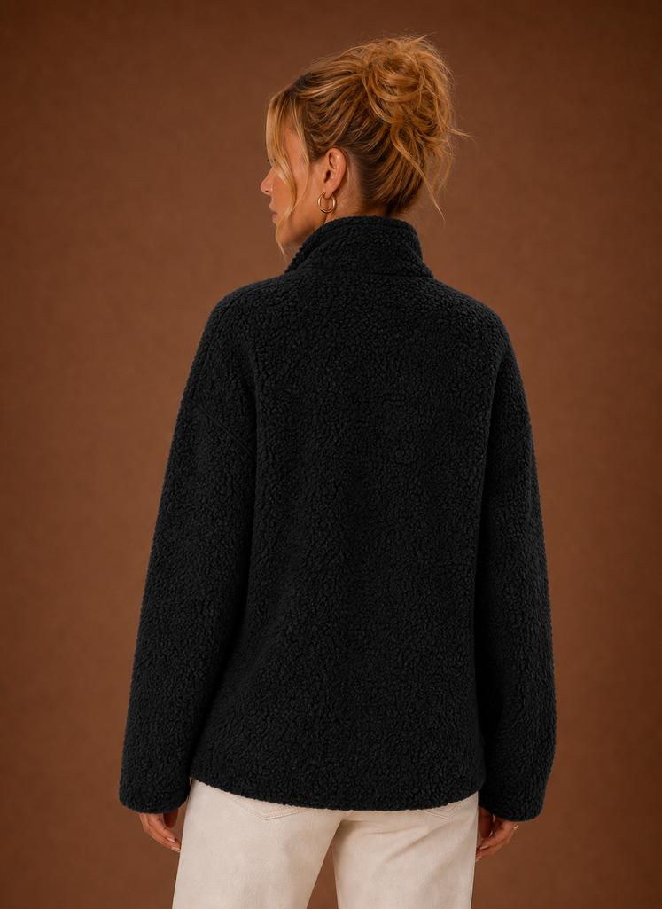 Detailaufnahme der kuscheligen Sherpa-Textur einer Damen-Reißverschlussjacke. Weiches Teddyfell.