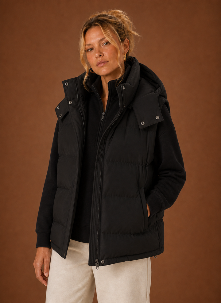 Schwarze Oversized Damen Steppweste mit Kapuze. Modische wattierte Übergangsjacke für kühle Tage.