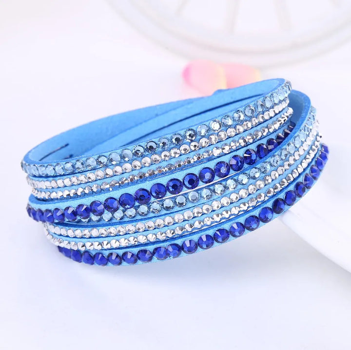 Unisex Glitzerarmband, mehrschichtig, mit funkelnden Strasssteinen auf dunklem Hintergrund. Eleganter Kontrast.