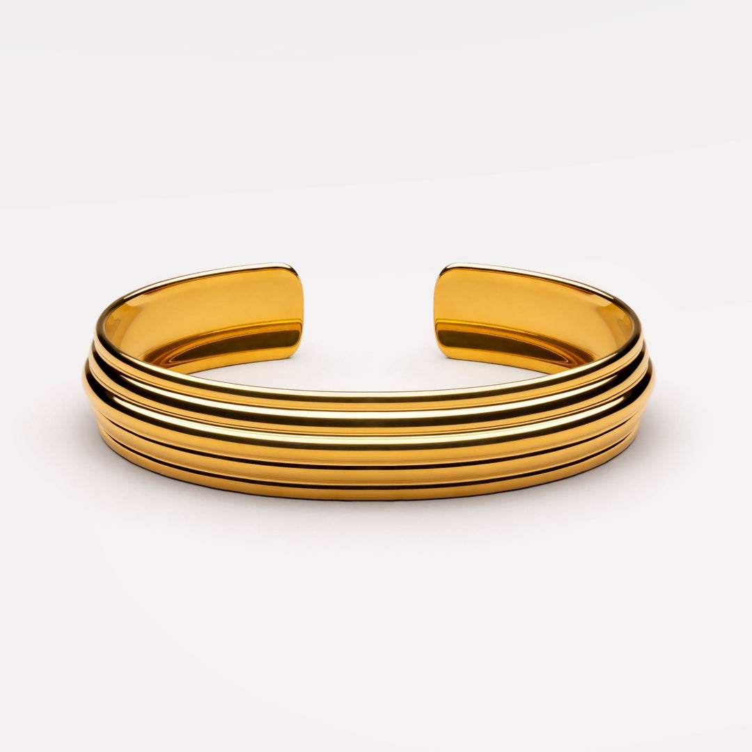 Damen Statement Armreif in Gold, skulpturales Design, breites Band aus Edelstahl, größenverstellbar.
