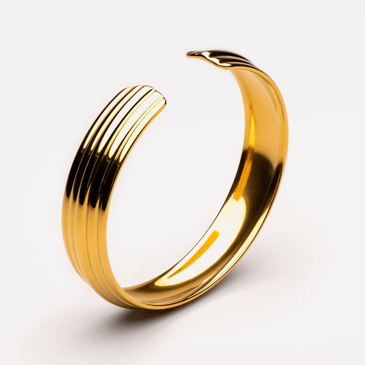Eleganter verstellbarer Gold Armreif für Damen, breit und skulptural, aus wasserdichtem Edelstahl.