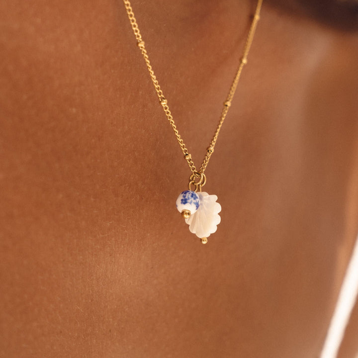Wasserfeste Damen Edelstahl Halskette mit maritimer Perlmutt Muschel und eleganter Keramikperle.