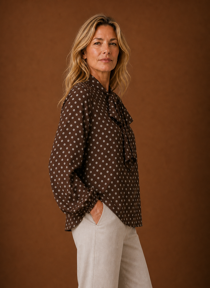 Damenbluse mit Punktemuster in Nahaufnahme; zeigt das klassische Design und die feine Textur der Bluse.