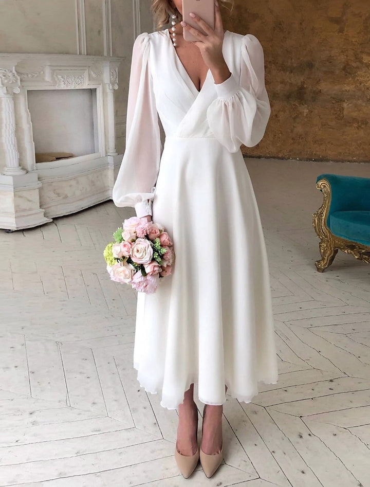 Elegantes weißes Damen Langarm Brautkleid mit tiefem V-Ausschnitt und fließendem Rock für die Hochzeit.