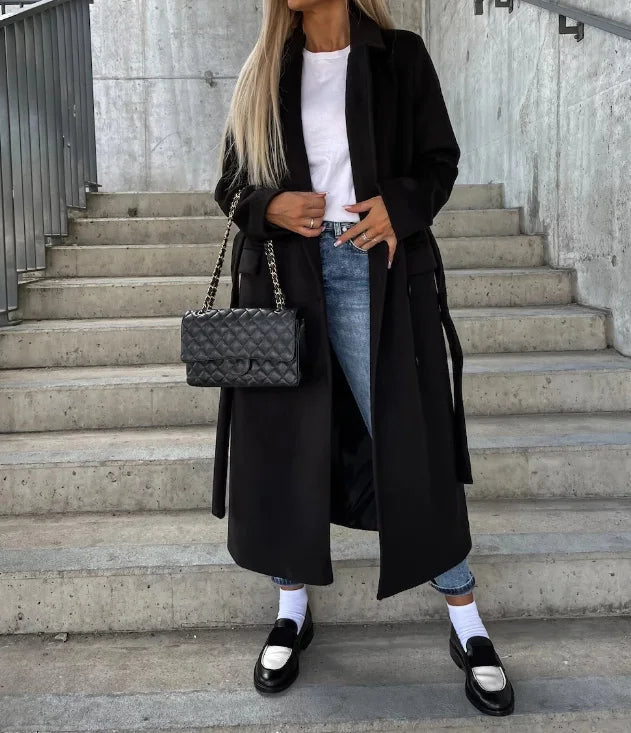Damen Herbst- & Wintermantel, langer Schnitt, stilvoll an Model von hinten gezeigt. Perfekt für kalte Tage.