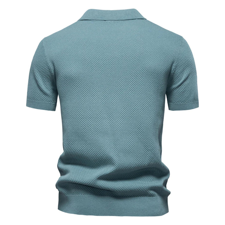 Nahaufnahme des strukturierten Gewebes vom Herren Poloshirt Elio. Hochwertiges, atmungsaktives Kurzarm-Oberteil.