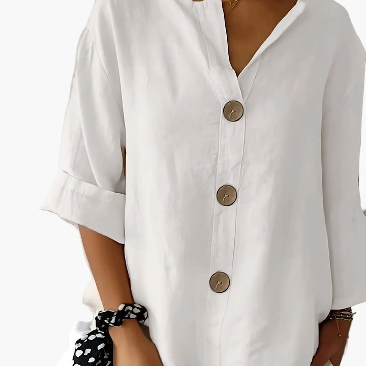 Apricotfarbene Damenbluse mit 3/4-Arm, V-Ausschnitt & durchgehender Knopfleiste; feminine Mode.