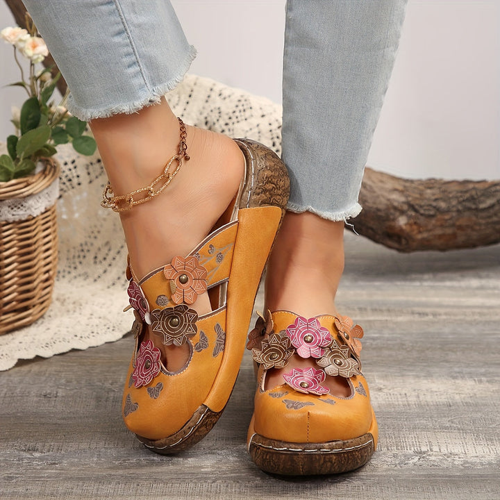 Frauen tragen stilvolle Keilabsatz-Pantoletten im Boho-Look, mit Blumen & Schmetterlingen, perfekt für Sommer.