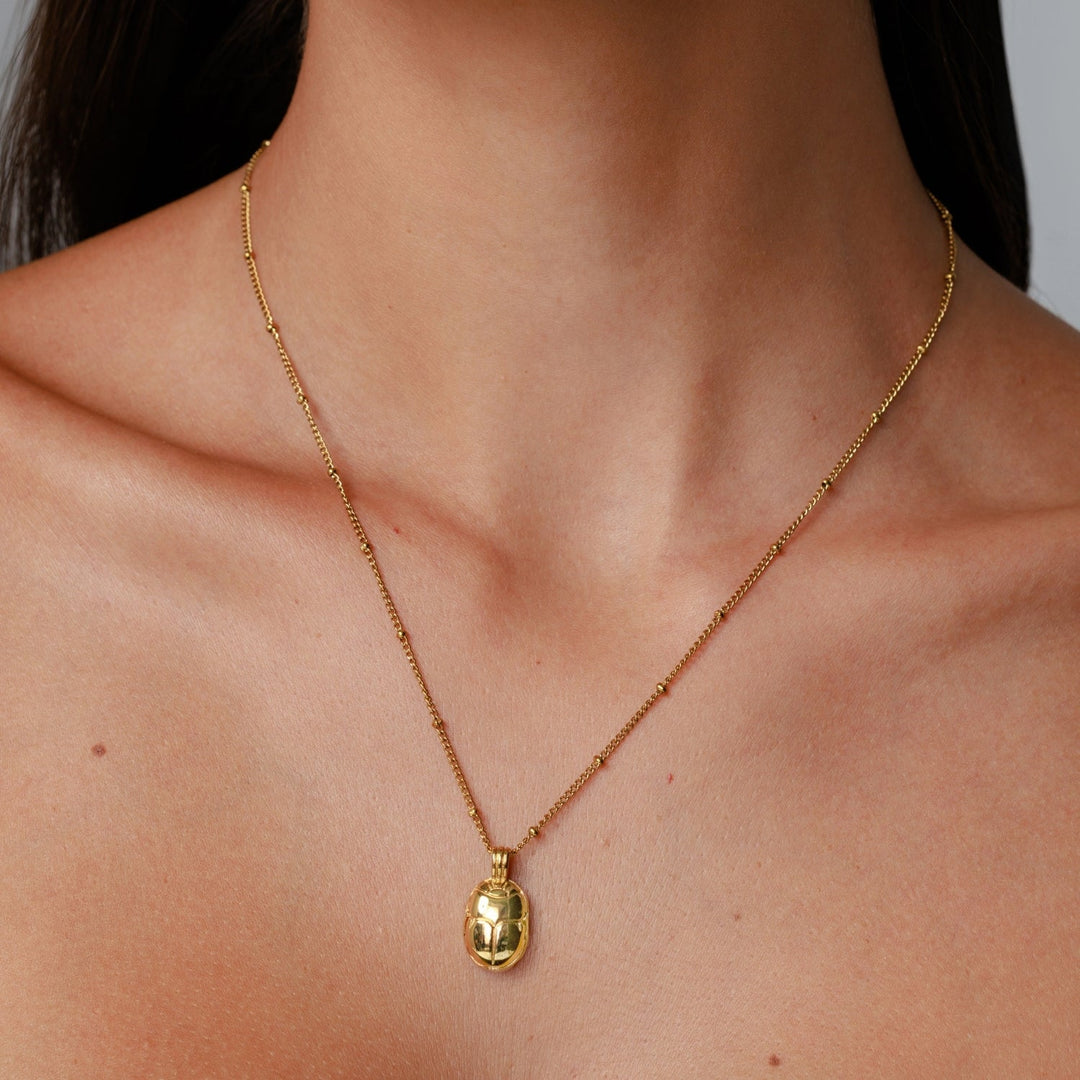 Elegante goldene Skarabäus Halskette mit grünem Zirkonia Anhänger. Moderner Damenschmuck, wasserfest.