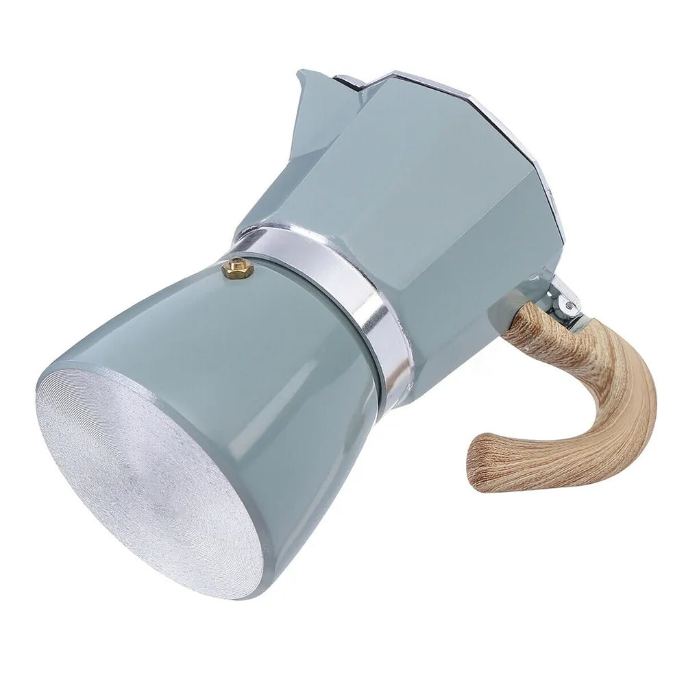 Frisch gebrühter aromatischer Espresso dampft aus dem eleganten Aluminium Perkolator.