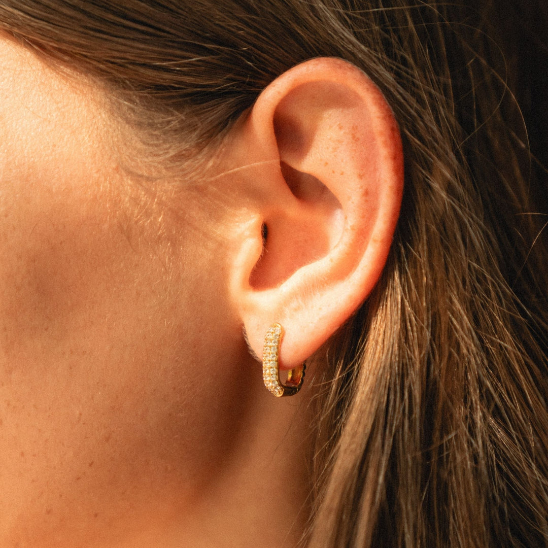Schlichte, aber glänzende goldene Huggie Creolen für Damen mit Zirkonia, ideal für den Alltag.