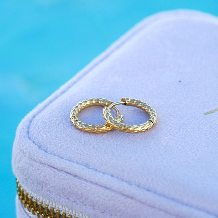 Edle goldene, gehämmerte Creolen für Damen, aus wasserfestem Edelstahl gefertigt. Hypoallergener Schmuck.