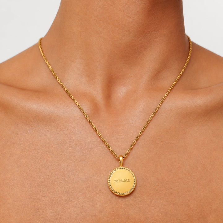 Detailaufnahme des personalisierbaren Gravur-Anhängers einer goldenen Damenhalskette aus wasserdichtem Edelstahl.