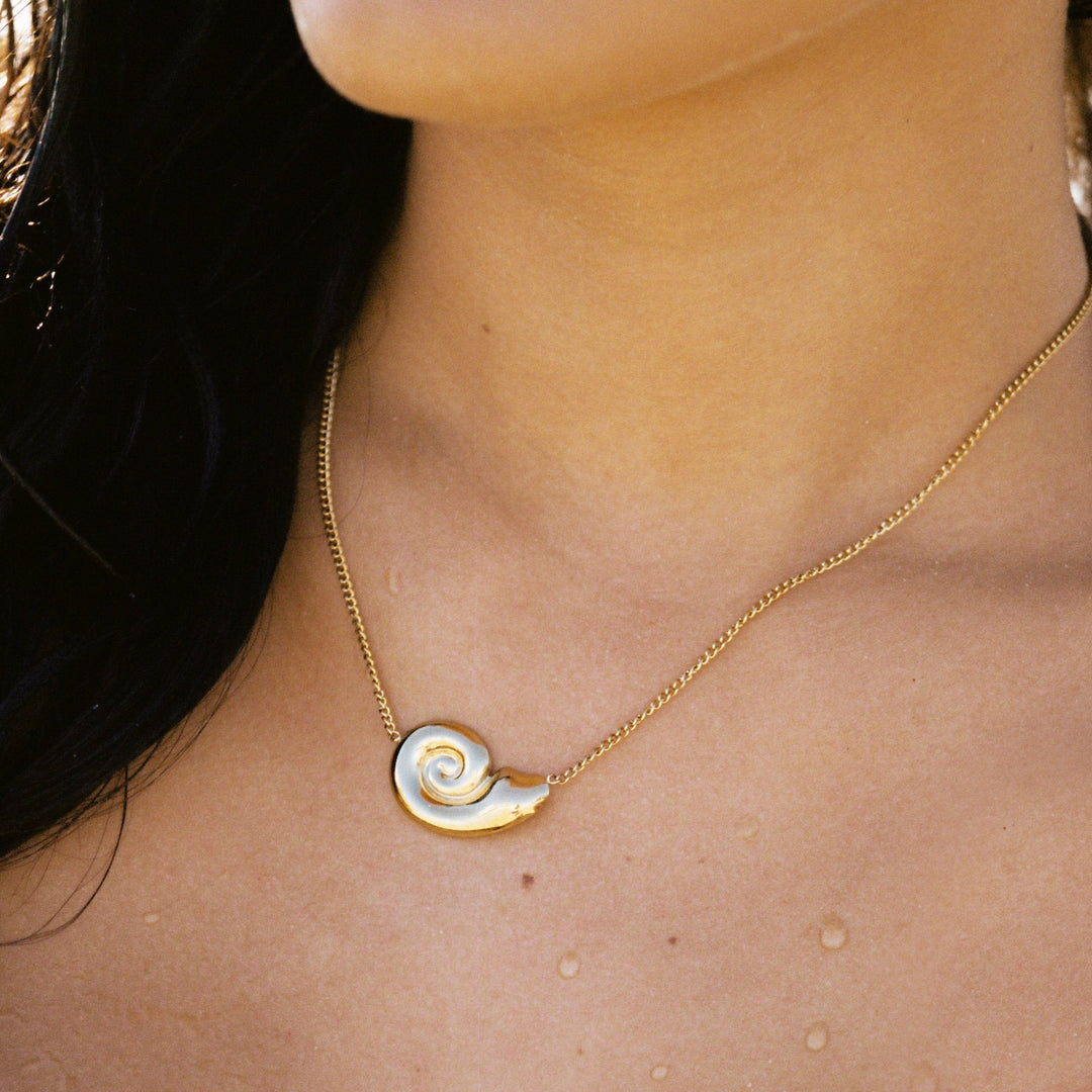 Elegante goldene Damenhalskette mit detailliertem Nautilus-Muschel-Anhänger aus wasserfestem Edelstahl.