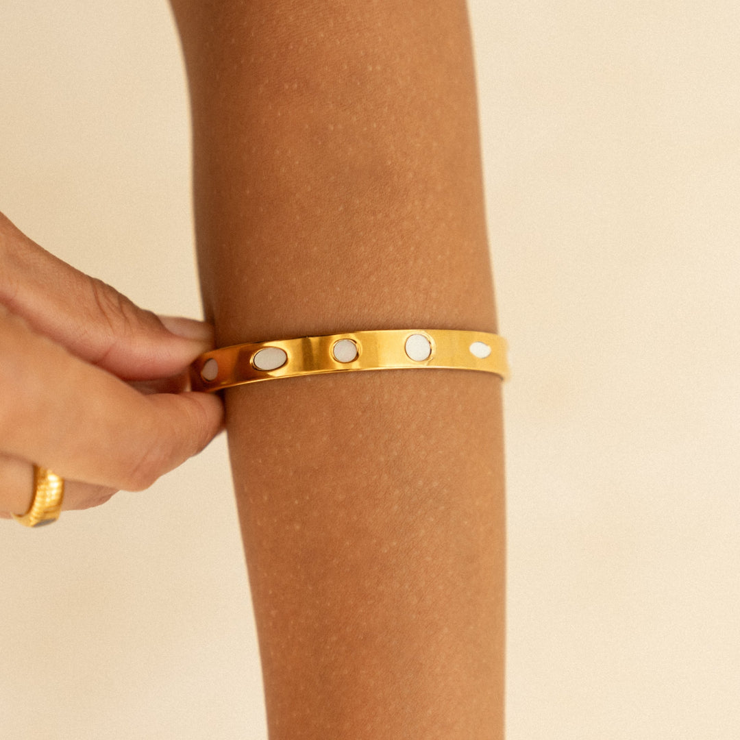 Nahaufnahme: Wasserfester Damen Gold Armreif mit schimmerndem Perlmutt. Hautfreundlicher Edelstahlschmuck.