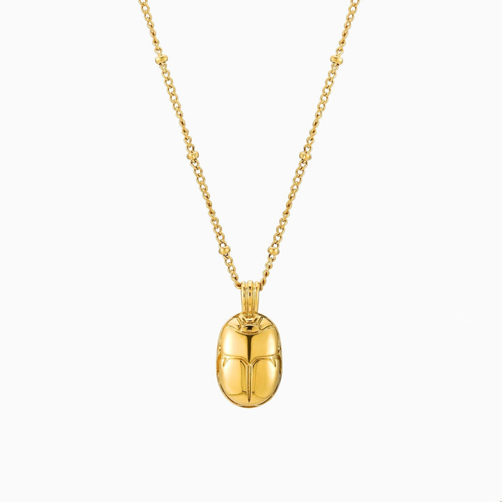 Model trägt goldene Skarabäus Halskette mit grünem Zirkonia. Stilvoller, wasserfester Damenschmuck.
