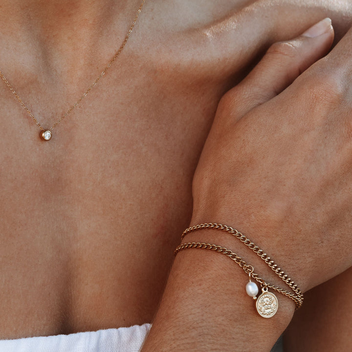 Elegantes, wasserfestes Damen Gold Armband mit glänzendem Münzanhänger und natürlicher Süßwasserperle.