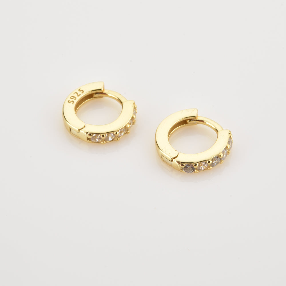 Nahaufnahme von funkelnden Damen Pave Creolen aus Gold, detailreich mit vielen glänzenden Zirkonia.
