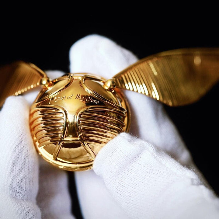Elegante goldene Schnatz Ringbox auf dunklem Samt, ideal als Hochzeits- oder Verlobungsgeschenk.