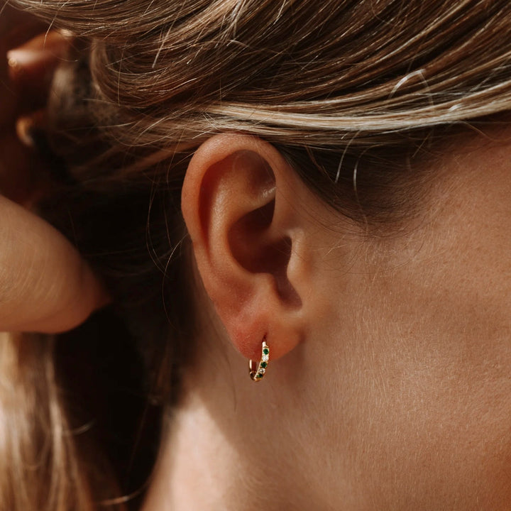 Elegante Damen Creolen aus goldfarbenem Edelstahl mit funkelnden grünen Kristallen, wasserfest & hypoallergen.
