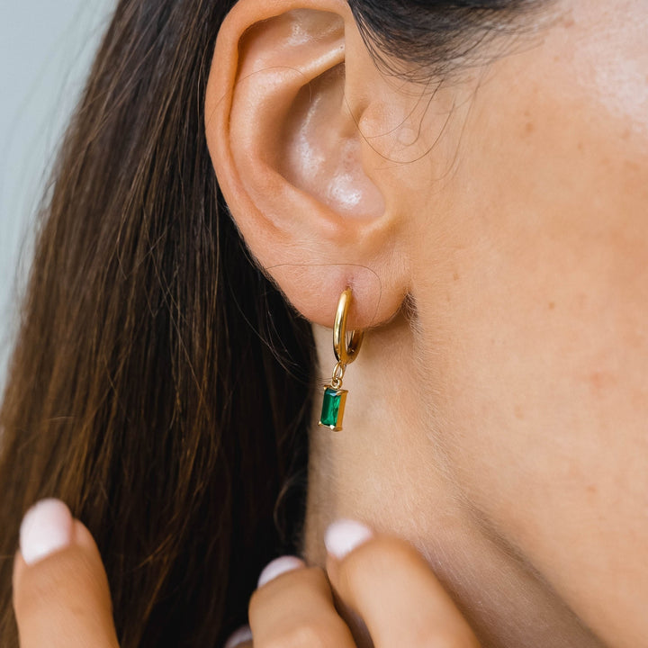 Detailaufnahme: Glänzende Damen Creolen mit prächtigen grünen Zirkonia in Edelstahlfassung.
