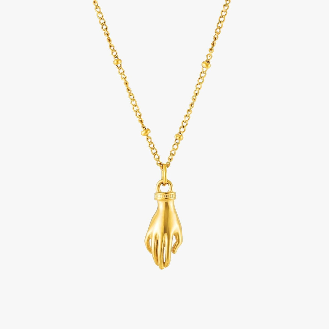 Nahaufnahme des Schutz Hand Anhängers mit leuchtend grünem Zirkon an goldfarbener Damenhalskette.