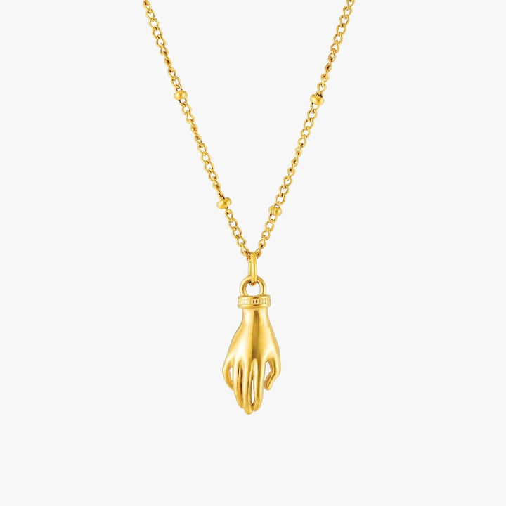 Nahaufnahme des Schutz Hand Anhängers mit leuchtend grünem Zirkon an goldfarbener Damenhalskette.