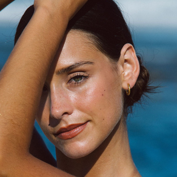 Stilvolle, goldene, gehämmerte Creolen für Damen. Wasserfeste, hypoallergene Ohrringe aus Edelstahl.