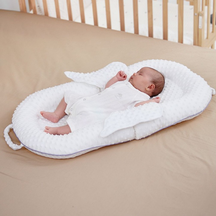 Ergonomisches Babynest für Neugeborene mit atmungsaktiver Mesh-Liegefläche und stützender Rückenstütze.