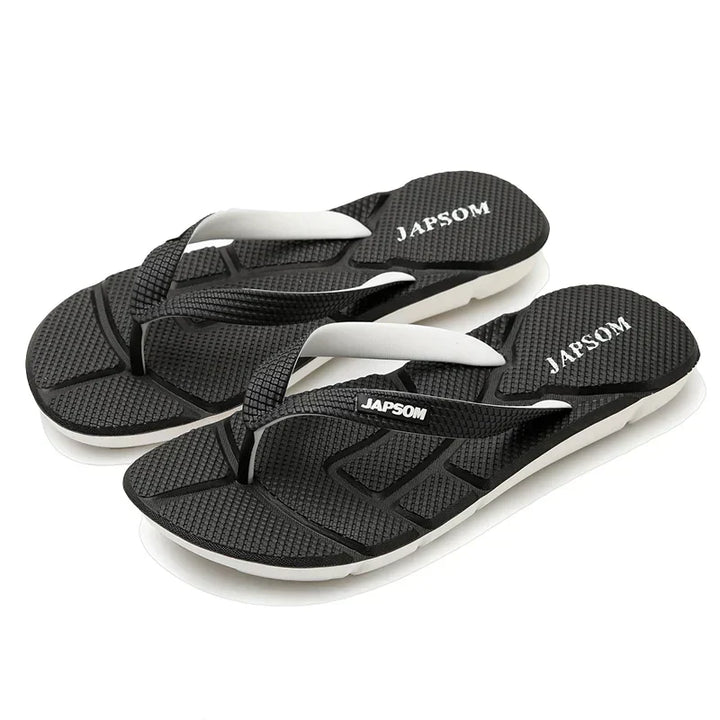 Mann trägt schwarze Herren Massage-Flip-Flops im Freien, genießt Komfort und entspannte Schritte.