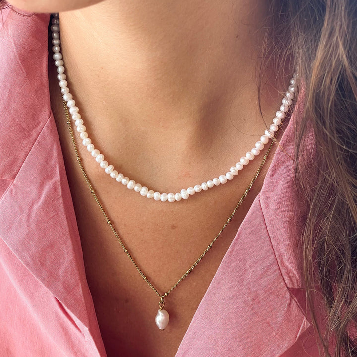 Damen Choker Kette aus Gold mit Süßwasserperlen am Hals einer Frau, verstellbar.