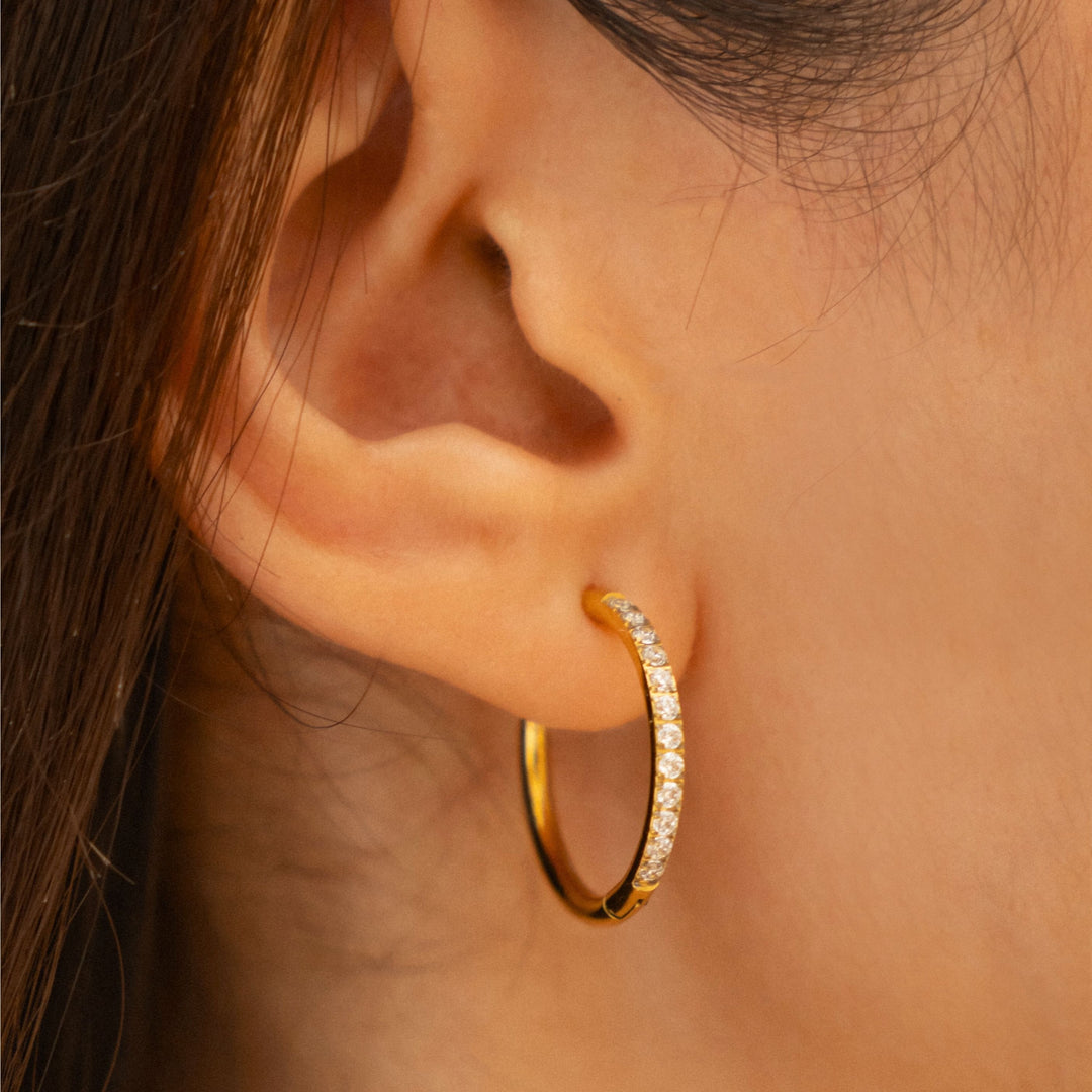 Damen Huggie Creolen goldfarben mit Zirkonia-Pavé. Funkelnde wasserfeste Ohrringe aus Edelstahl.