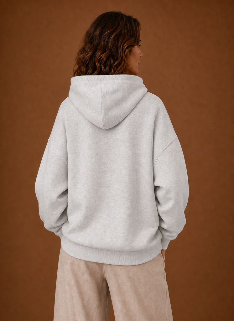 Lachendes Model im grauen Oversized Kapuzenpullover mit Print, lässige Damenbekleidung.