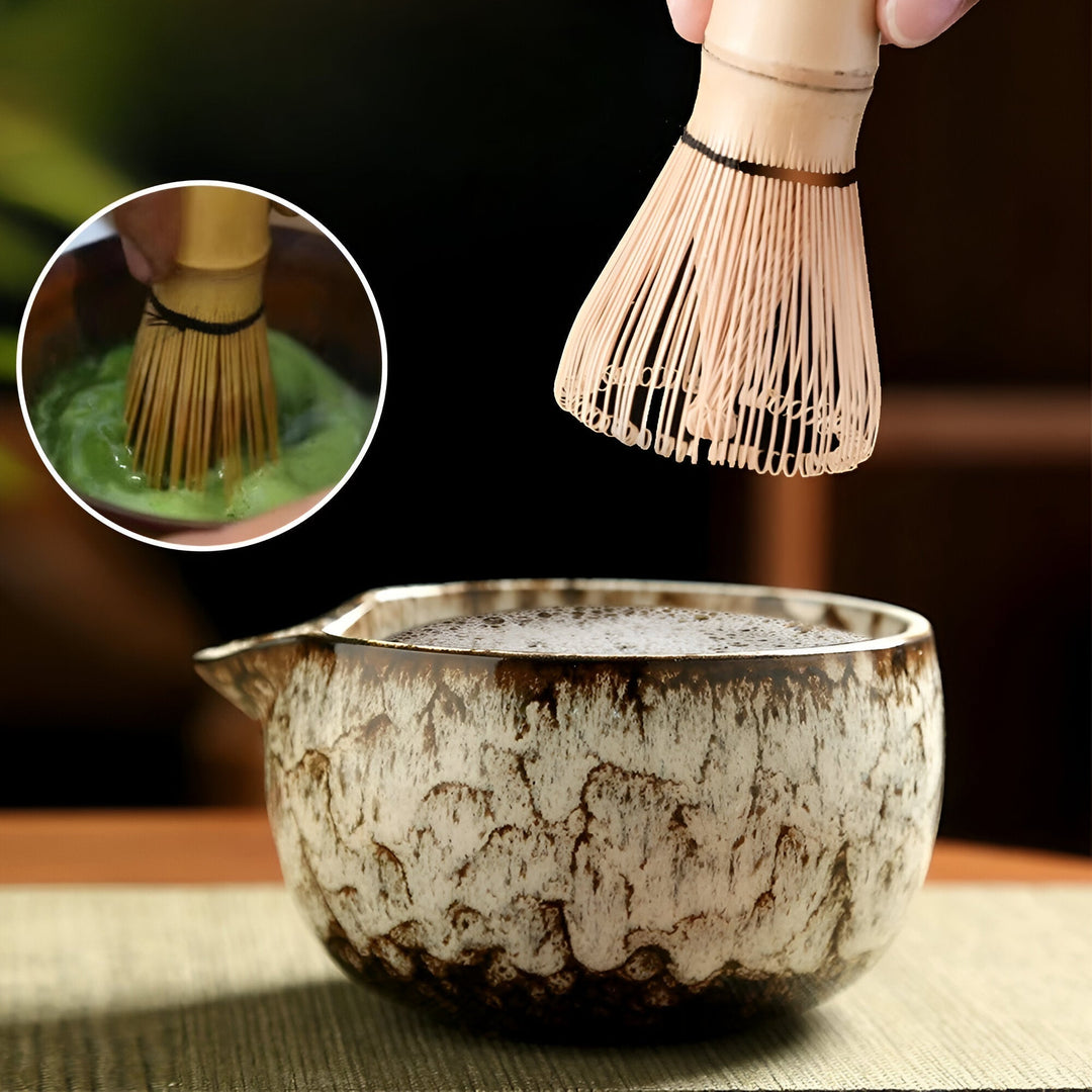 Authentisches Matcha Teezeremonie Set bei der Zubereitung; Bambusbesen schlägt Matcha in Keramikschale auf.