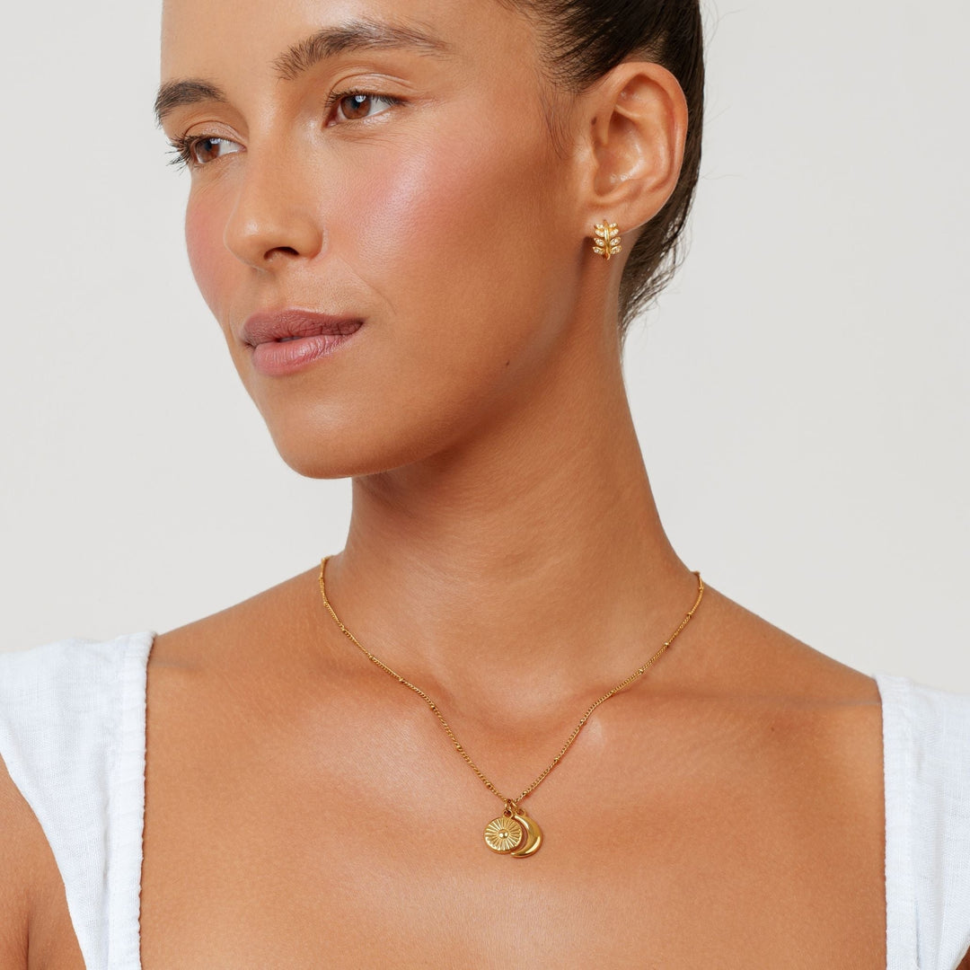 Nahaufnahme des goldenen Sonne Mond Anhängers einer eleganten Damen Halskette aus Edelstahl.