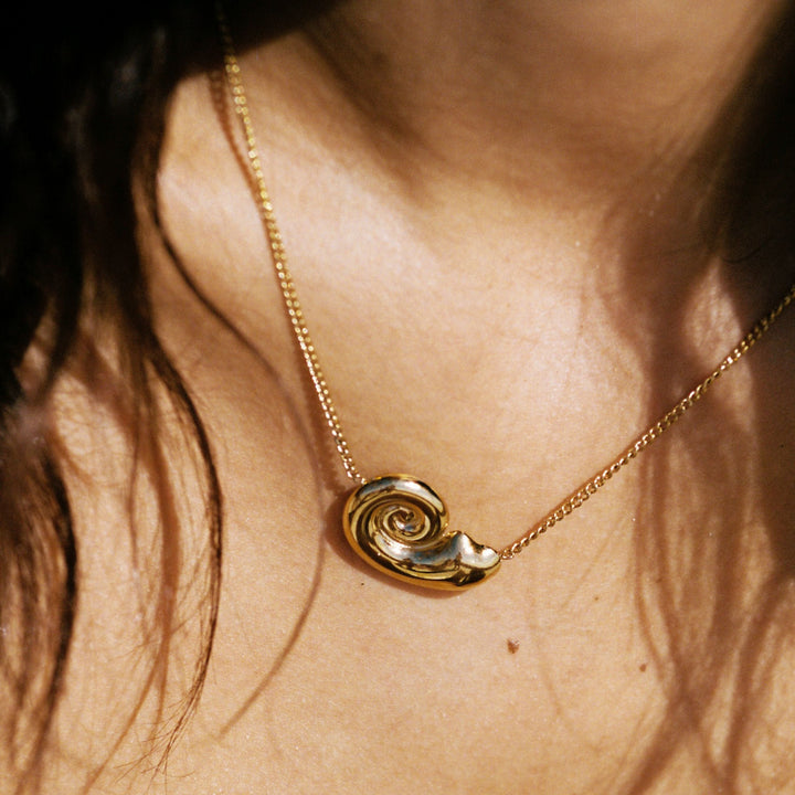 Wasserfeste Damenhalskette aus goldfarbenem Edelstahl mit Nautilus-Muschel-Anhänger. Langlebiger Maritim-Schmuck.