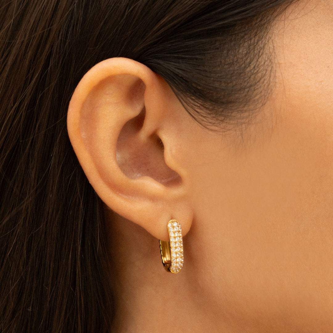 Goldene Huggie Creolen für Damen mit funkelnden Zirkonia-Steinen, wasserdicht & hypoallergen.