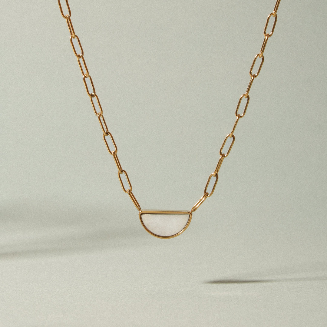 Neue goldene Choker Halskette mit Perlmutt Anhänger. Hypoallergener Damenschmuck auf Schmuckständer präsentiert.