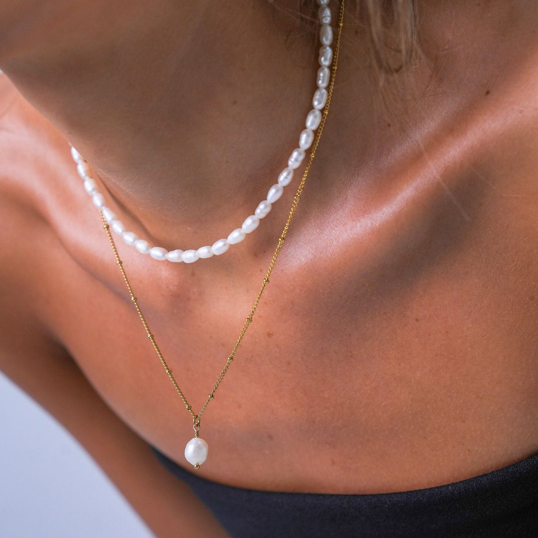 Model trägt goldenes Damen Perlen Schmuckset, Süßwasser-Choker & Barockperlen-Kette für eleganten Look.