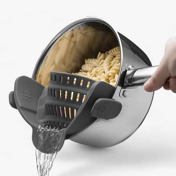 Graues, faltbares Silikon-Küchensieb für Gemüse & Pasta. Platzsparend, lebensmittelecht, spülmaschinenfest. Ein praktischer Küchenhelfer.