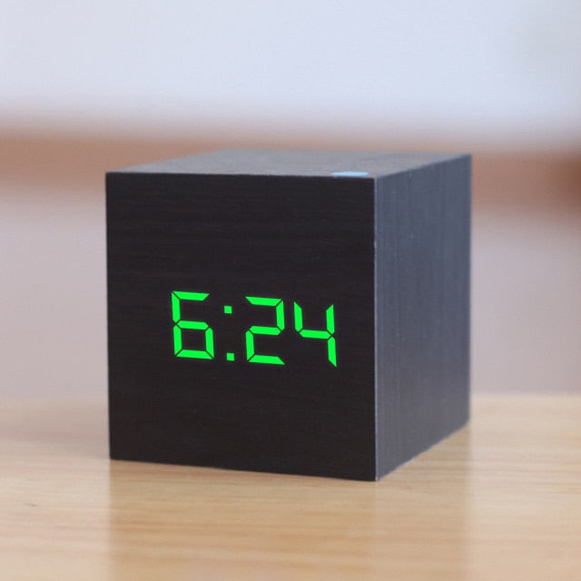 Stilvoller LED Würfelwecker auf einem Nachttisch, digitale Anzeige für Zeit und Weckfunktion im Schlafzimmer.