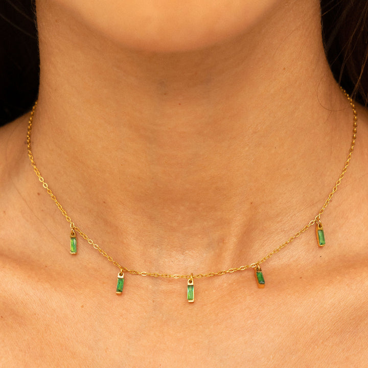 Nahaufnahme: Grüner Smaragdoptik Anhänger an filigraner goldener Choker Halskette für Damen.