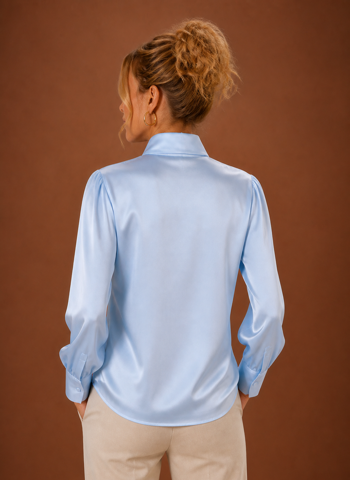 Flach liegende Damen Satin-Bluse in Weiß mit Schleife, langärmlig und locker geschnitten.