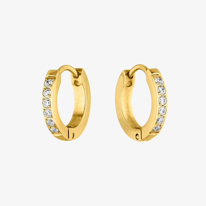 Nahaufnahme funkelnder Zirkonia Steine auf einer goldenen Mini Creole für Damen. Hochwertiger Edelstahl Schmuck.