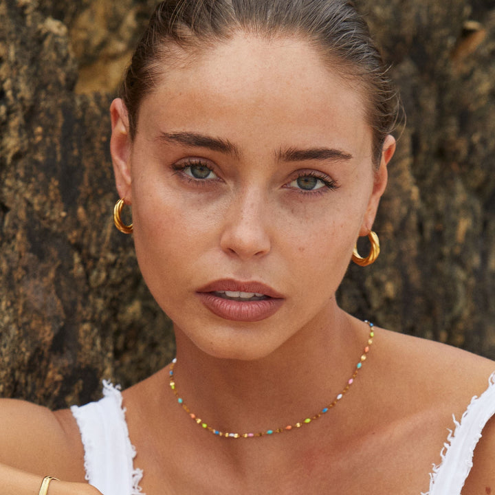 Nahaufnahme der strukturierten, gedrehten Damen Creolen Gold aus Edelstahl. Wasserdichter & hypoallergener Schmuck.
