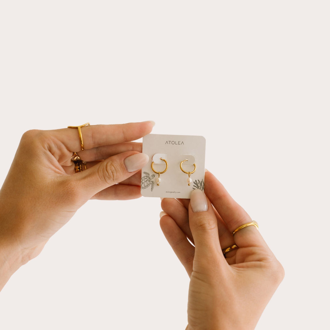 Hypoallergene goldene Huggie Creolen mit echten Süßwasserperlen. Wasserfester Damenschmuck.