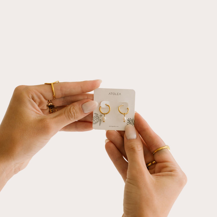Hypoallergene goldene Huggie Creolen mit echten Süßwasserperlen. Wasserfester Damenschmuck.