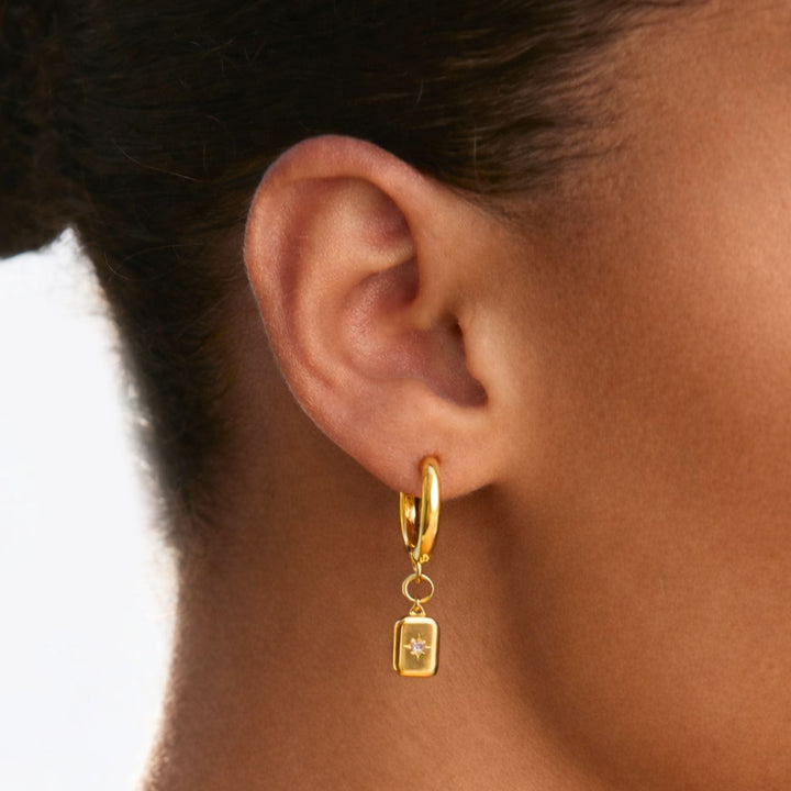 Goldene Damen Creolen mit glitzerndem Zirkonia-Sternanhänger. Wasserdichte, hypoallergene Edelstahl-Ohrringe.