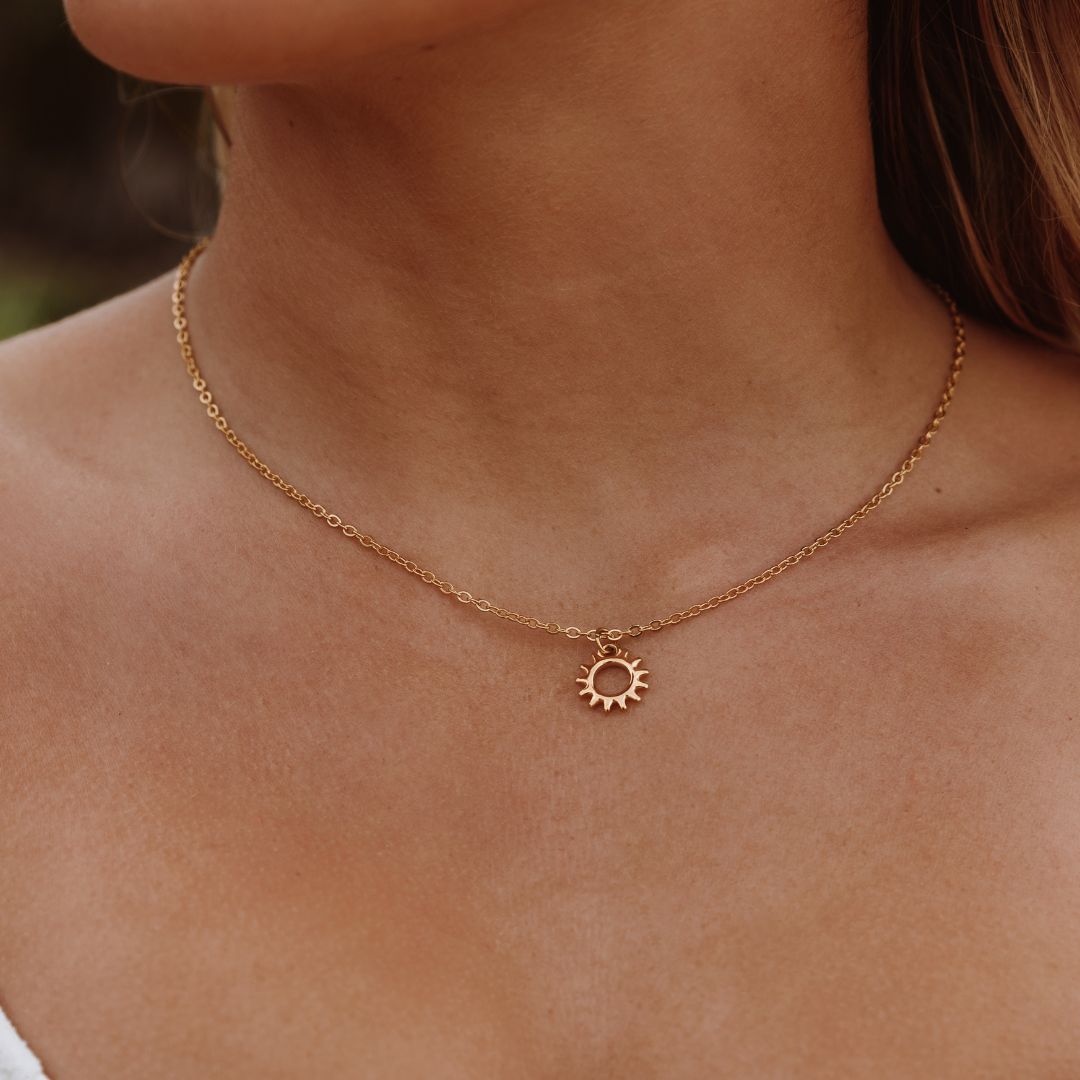 Detailaufnahme der goldenen Damenkette mit fein gearbeitetem Sonnenmedaillon. Wasserfester Edelstahl-Halsschmuck.