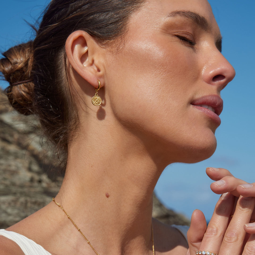 Detailansicht goldener Sonnen-Creolen aus wasserfestem Edelstahl, hypoallergen, Damenschmuck.